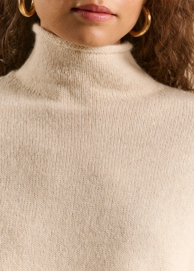 Pull avec un col montant roulotté et des manches longues